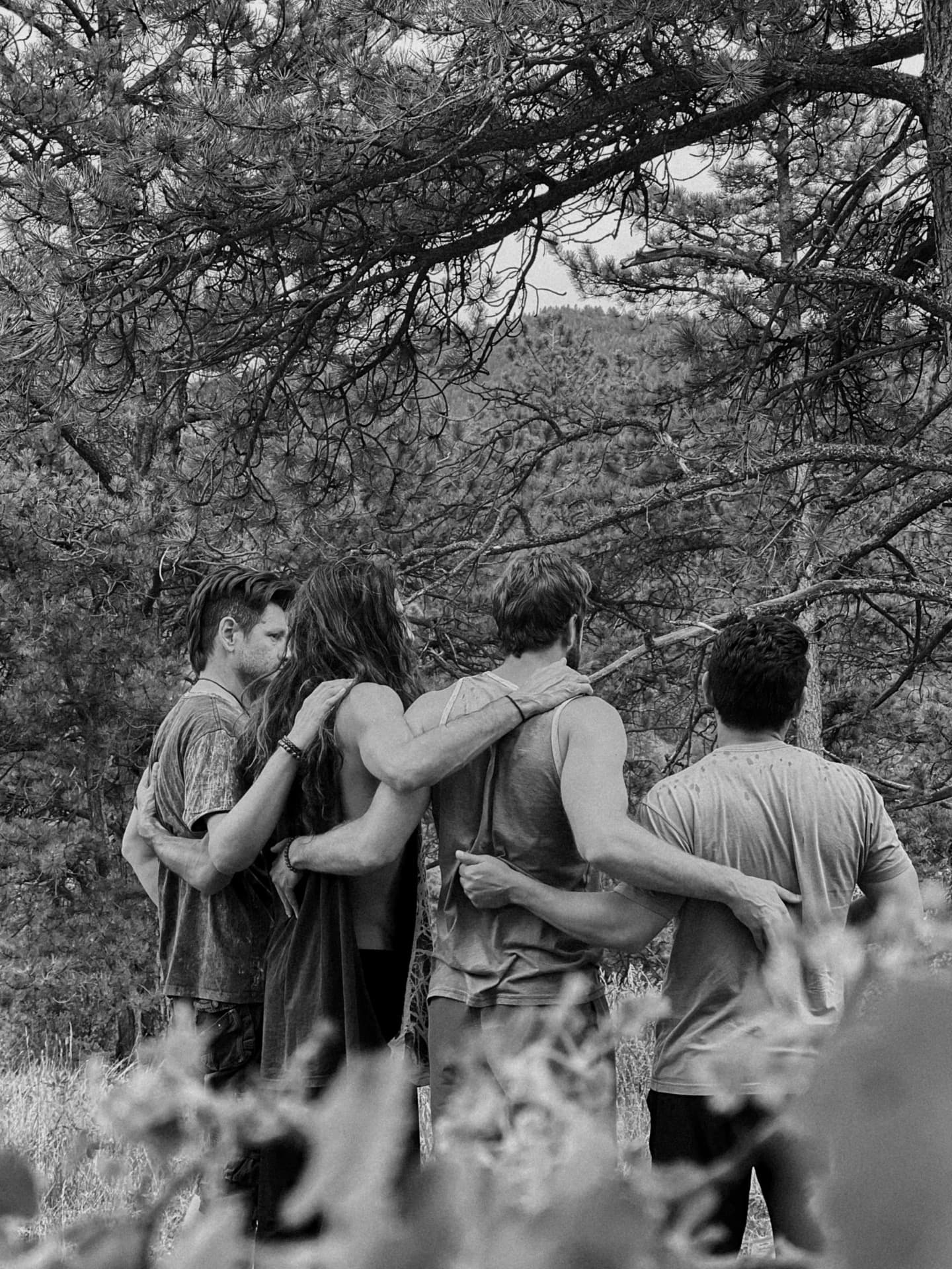 Group of participants embracing outdoors among trees during a healing retreat